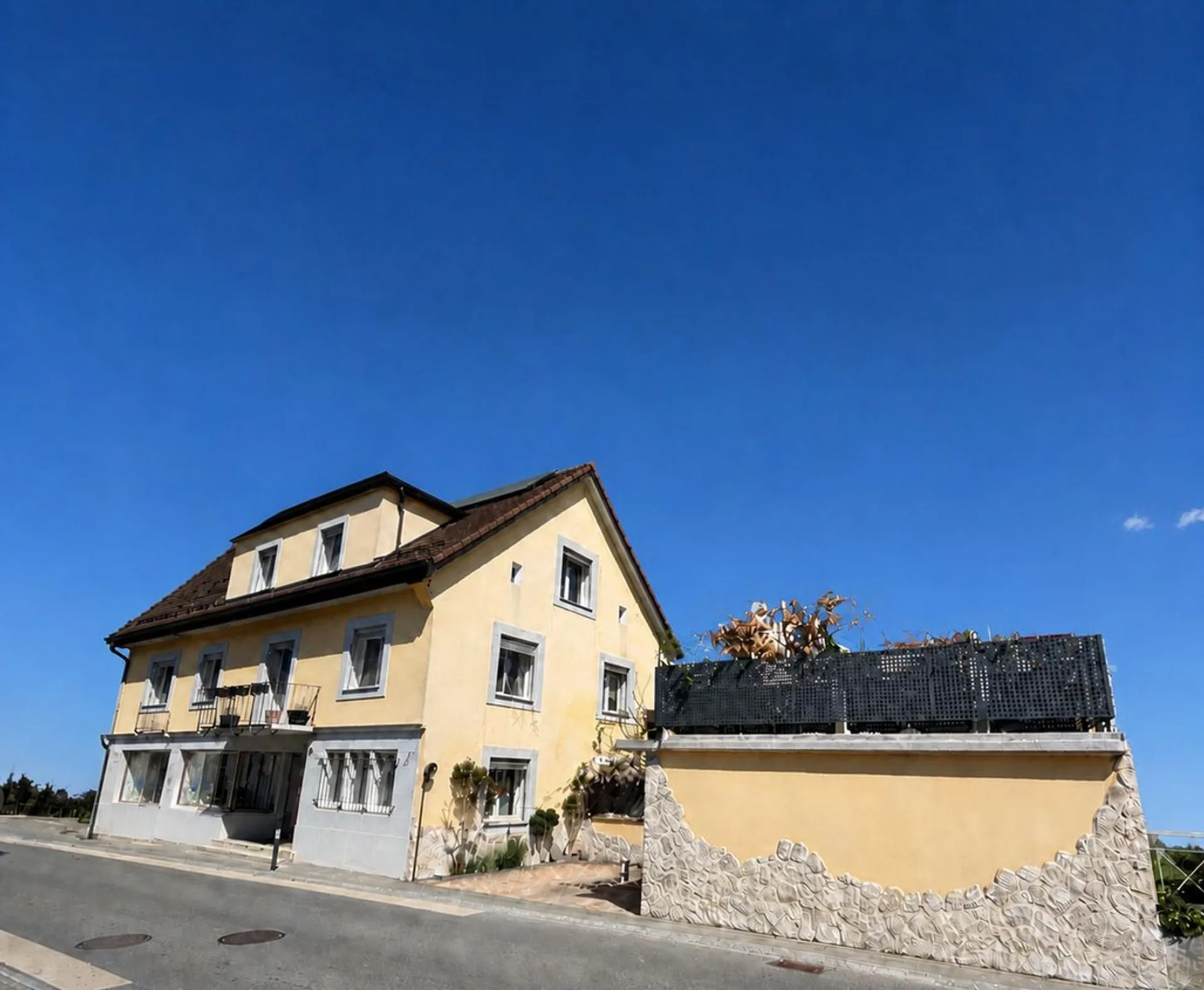 Immeuble de 2 appartements, un local commercial - 2 chambres- 2 places de parc et un garage/ Terrasse au centre du village